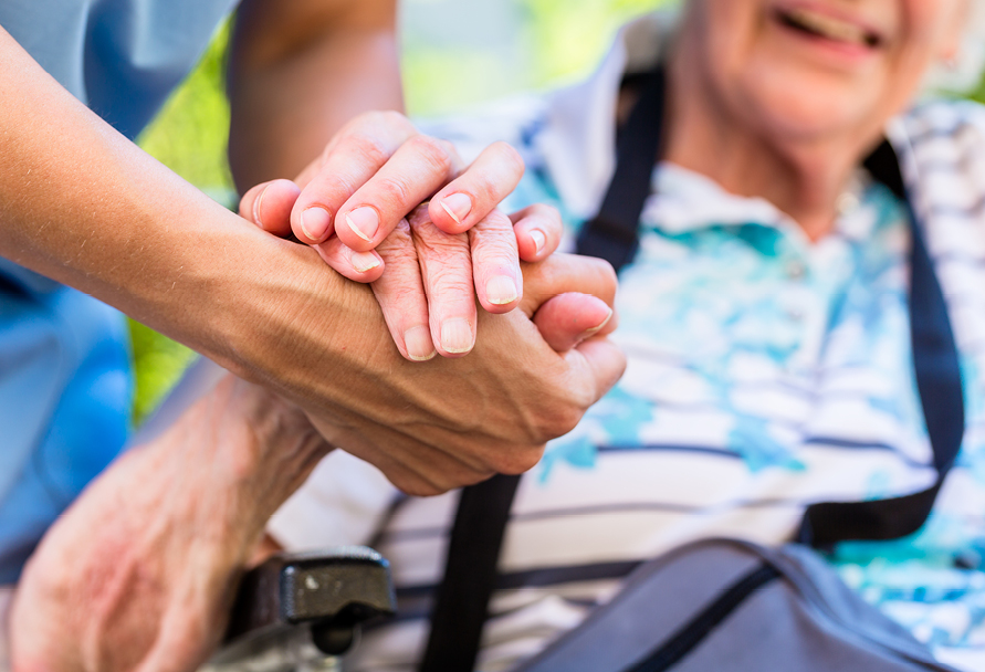 Close up of someone giving an elderly woman a helping hand