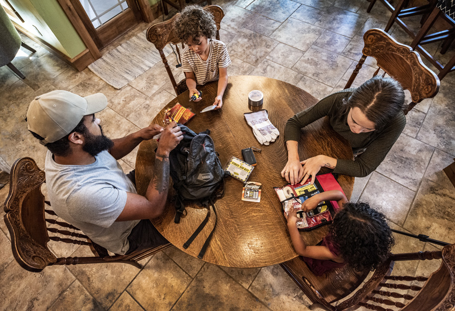Family at their dining table preparing an emergency kit together