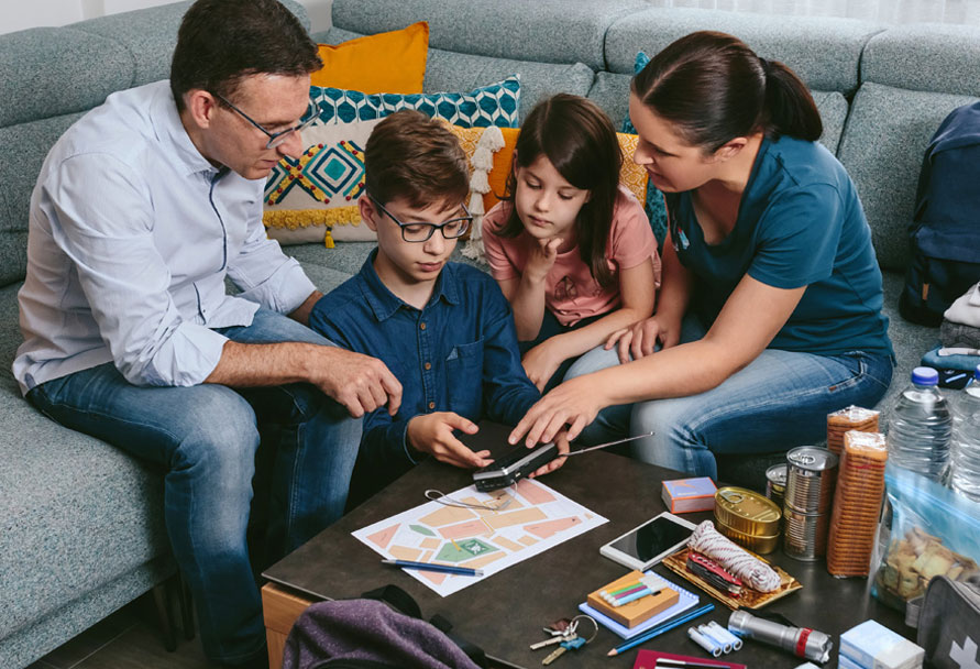 Family sitting on couch reviewing papers.