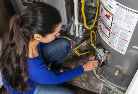 Woman adjusting the temperature on a water heater